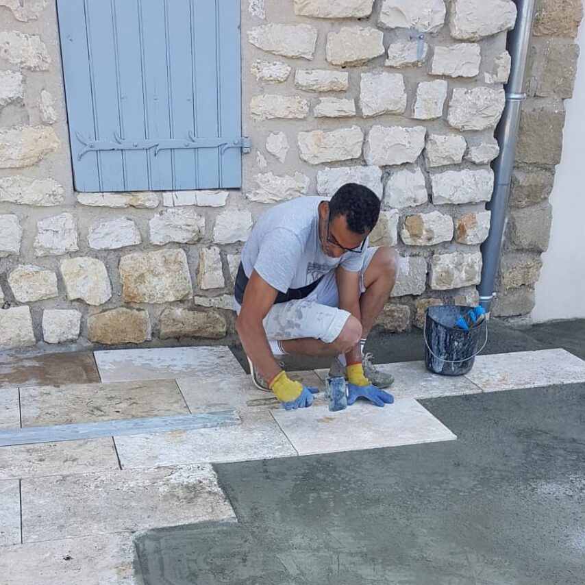 Maçon Hafafsa Constructions posant un dallage sur un chantier